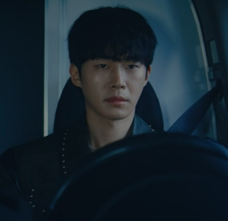 Gi Yeong-do dentro de um carro, à noite, com expressão fechada