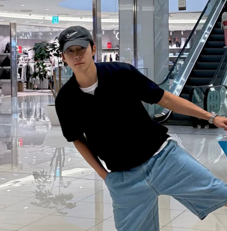 Moo Jin-sung de boné, numa foto casual de shopping