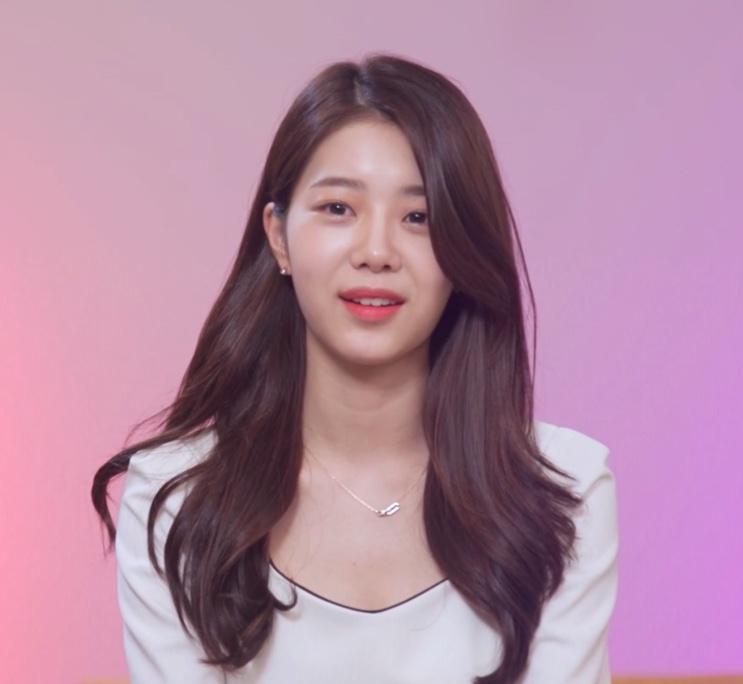 Han Chae-rin em entrevista do reality, sobre fundo rosa