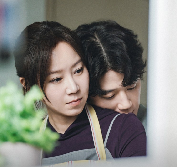 Bo-na e o marido Tae-seong abraçados na cozinha de casa