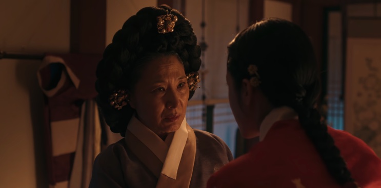A rainha-mãe conversando com uma dama da corte em A Leste do Palácio