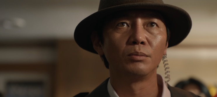 Kang Guk-cheol de chapéu, em close