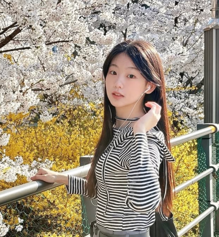 Seo Su-min diante de cerejeiras em flor