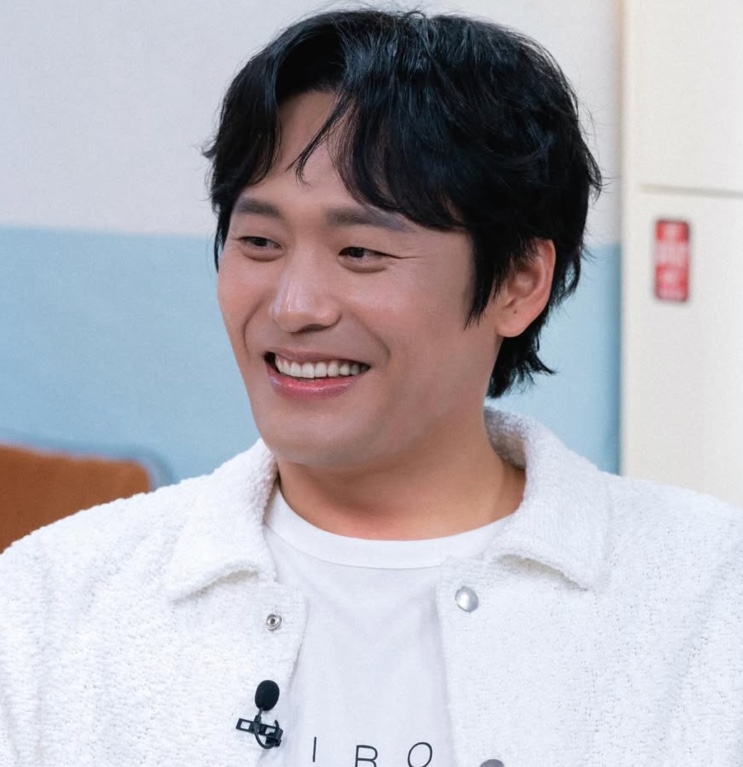 Choi Dae-hoon de jaqueta branca, sorrindo