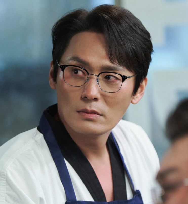 Sung Han-soo de uniforme de taekwondo e óculos, em Agente Kim