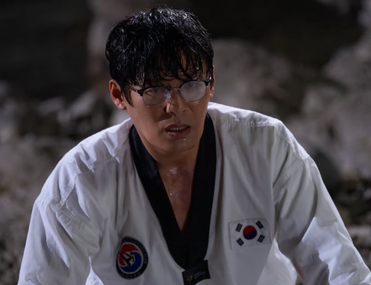 Sung Han-soo suado, de uniforme de taekwondo, olhando para baixo