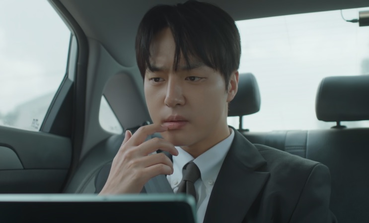 Ji-hwan pensativo dentro de um carro