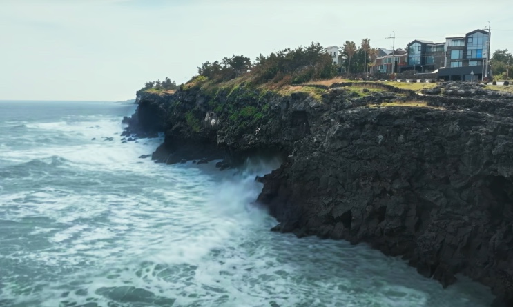 Vista do penhasco de rocha vulcânica com o mar batendo, em Jeju