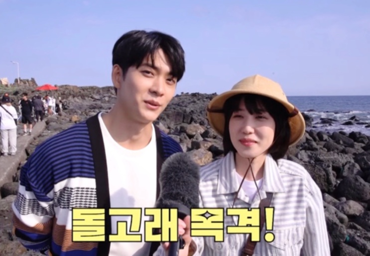 Casal em programa de TV apontando para golfinhos avistados na costa de Jeju