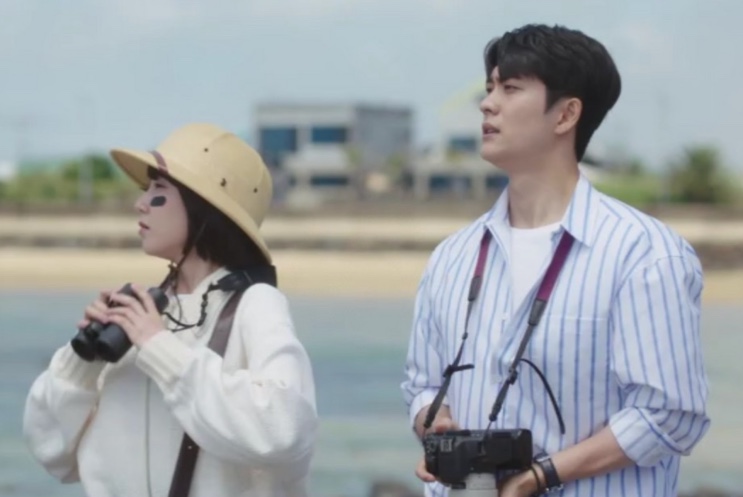 Cena de Woo, Uma Advogada Extraordinária com dois personagens observando o mar com binóculos
