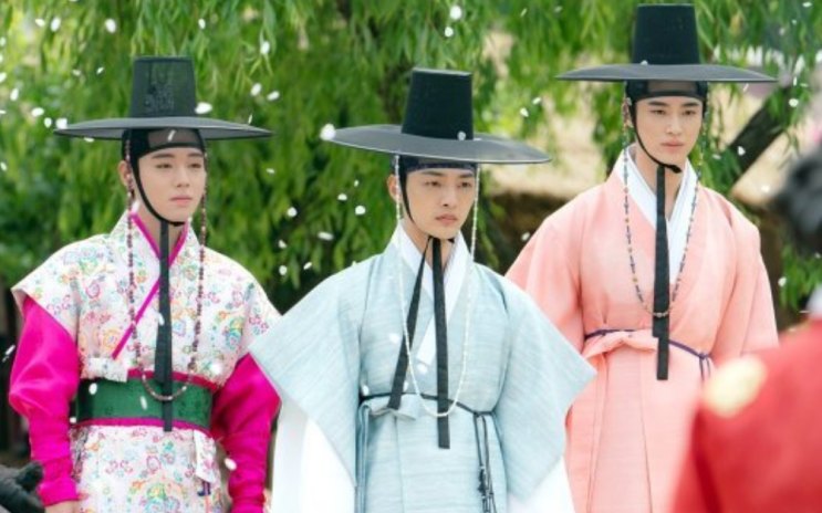 Os três casamenteiros da Kkotpadang de hanbok, caminhando lado a lado ao ar livre