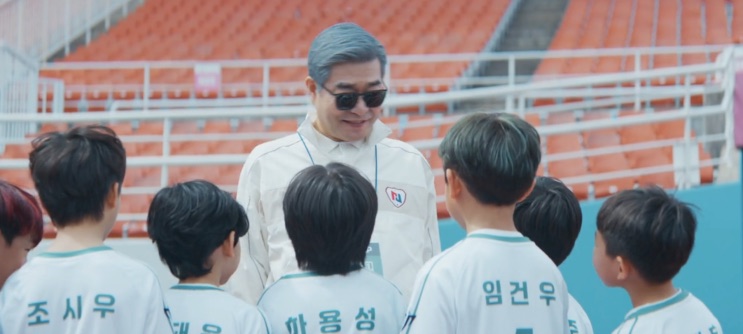 Kang Yong-ho de óculos escuros com as crianças do time
