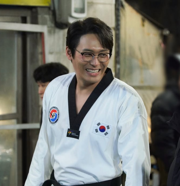 Sung Han-soo sorrindo de uniforme de taekwondo