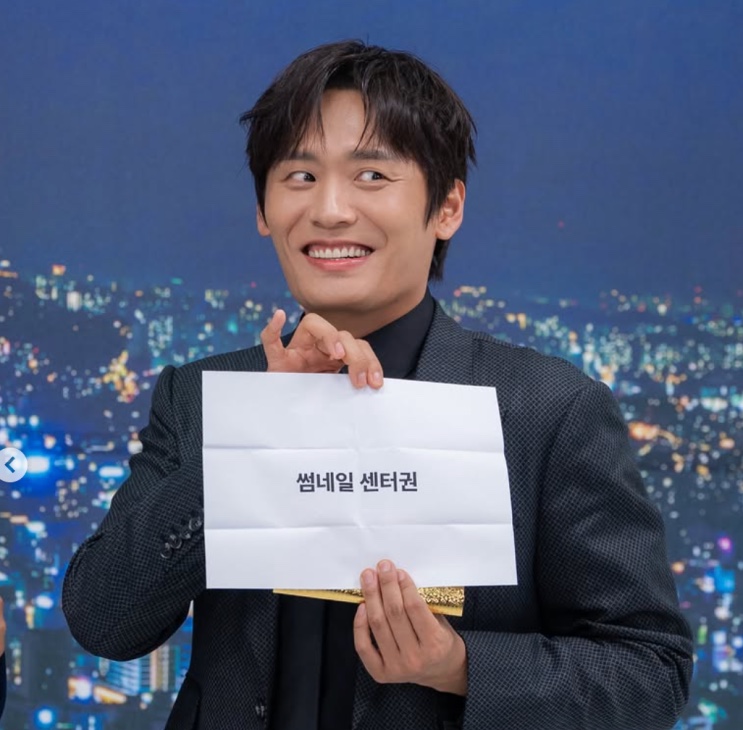 Choi Dae-hoon segurando uma placa em evento
