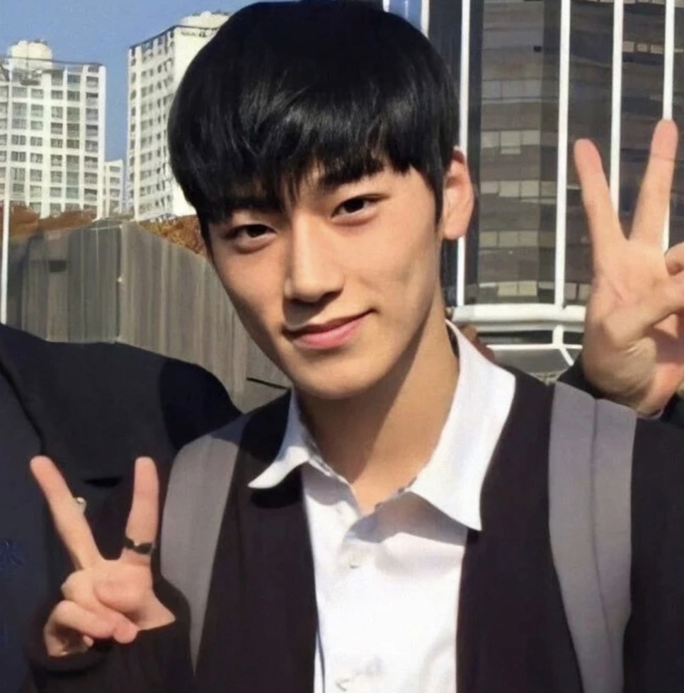 Choi San adolescente de uniforme escolar fazendo sinal de V, ao ar livre