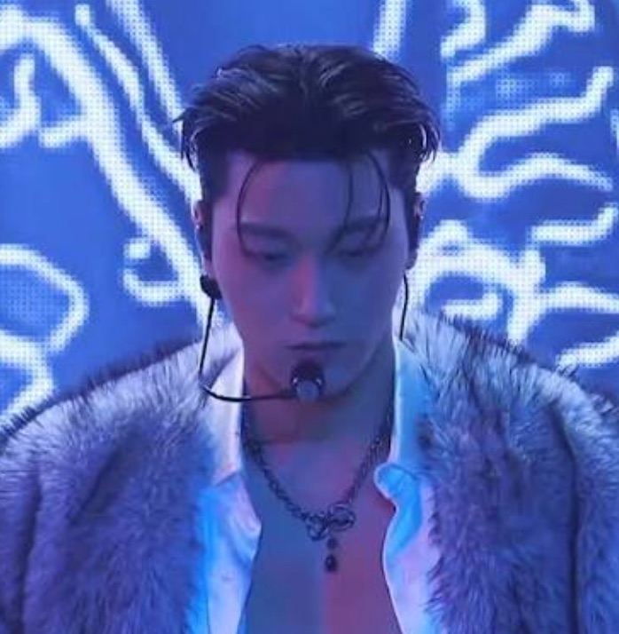 Choi San no palco de 'Ice On My Teeth', casaco de pelo e luz azul