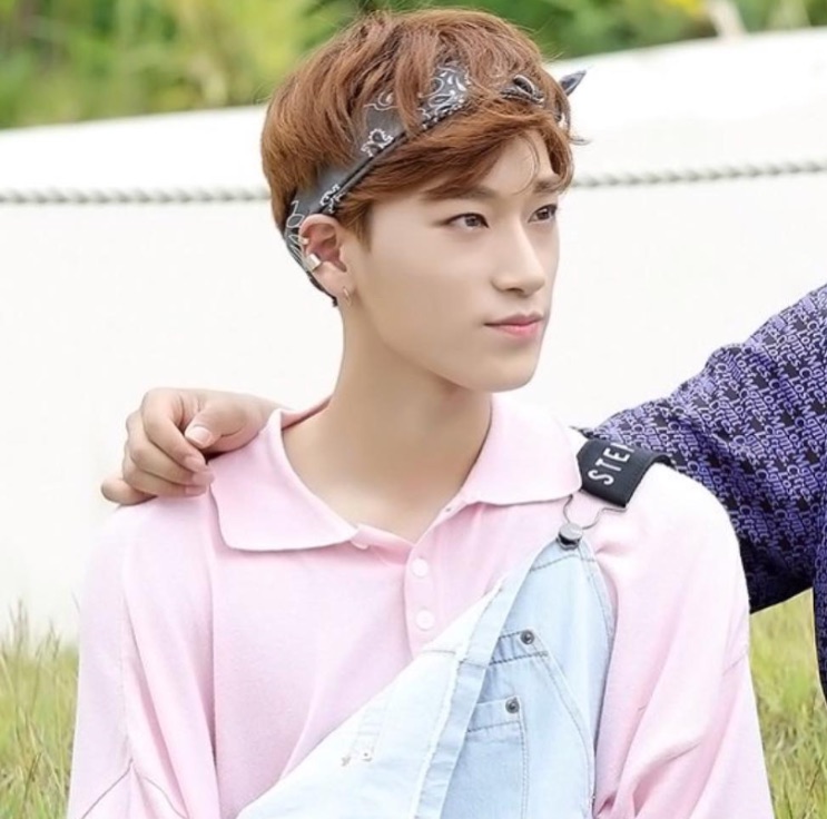 Choi San no debut, de polo rosa e bandana, rosto de menino