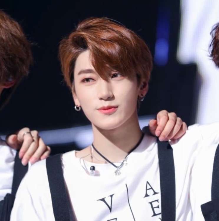 Choi San no debut, no palco de terno e suspensório