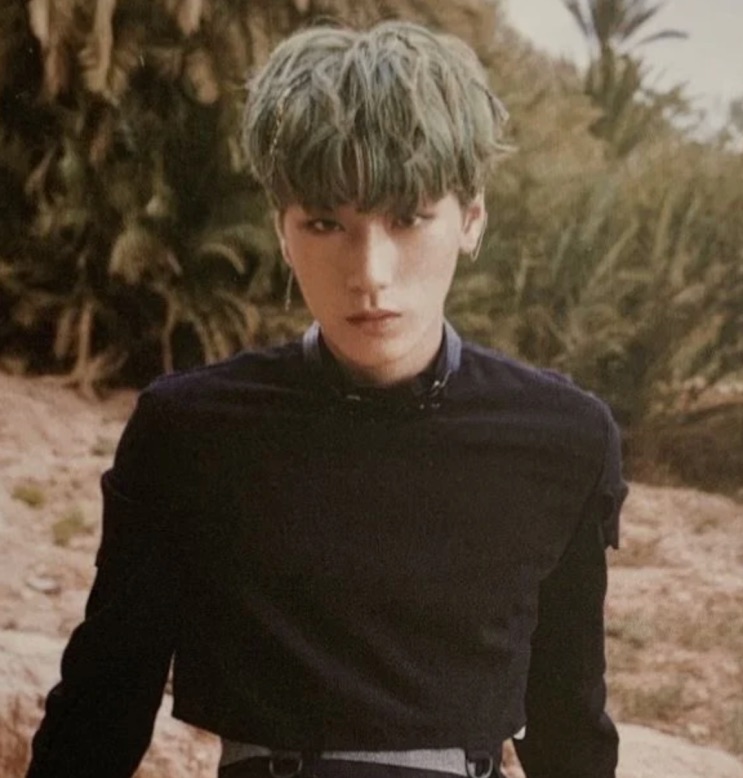 Choi San no debut, de cabelo verde e roupa preta