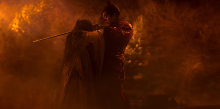 Gu-cheon golpeando um espírito com a espada, em meio ao fogo