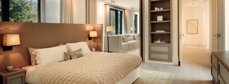 Quarto da casa, com cama de casal e abajures acesos