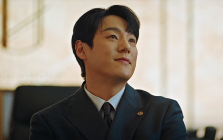 Jin Seung-joo de terno escuro, olhando para cima