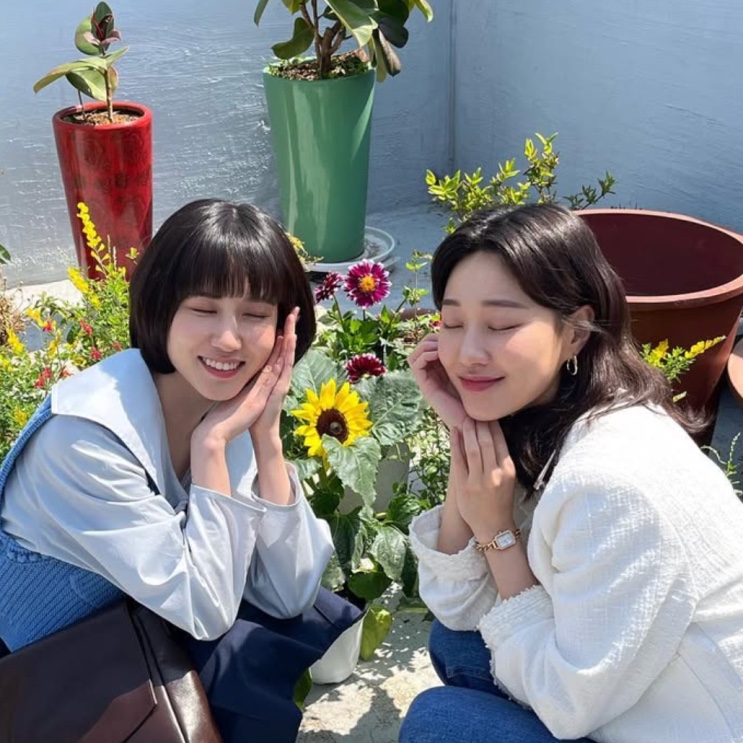 Ha Yoon-kyoung com uma amiga diante de girassóis