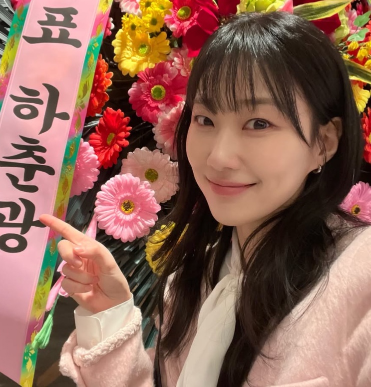 Ha Yoon-kyoung diante de flores cor-de-rosa