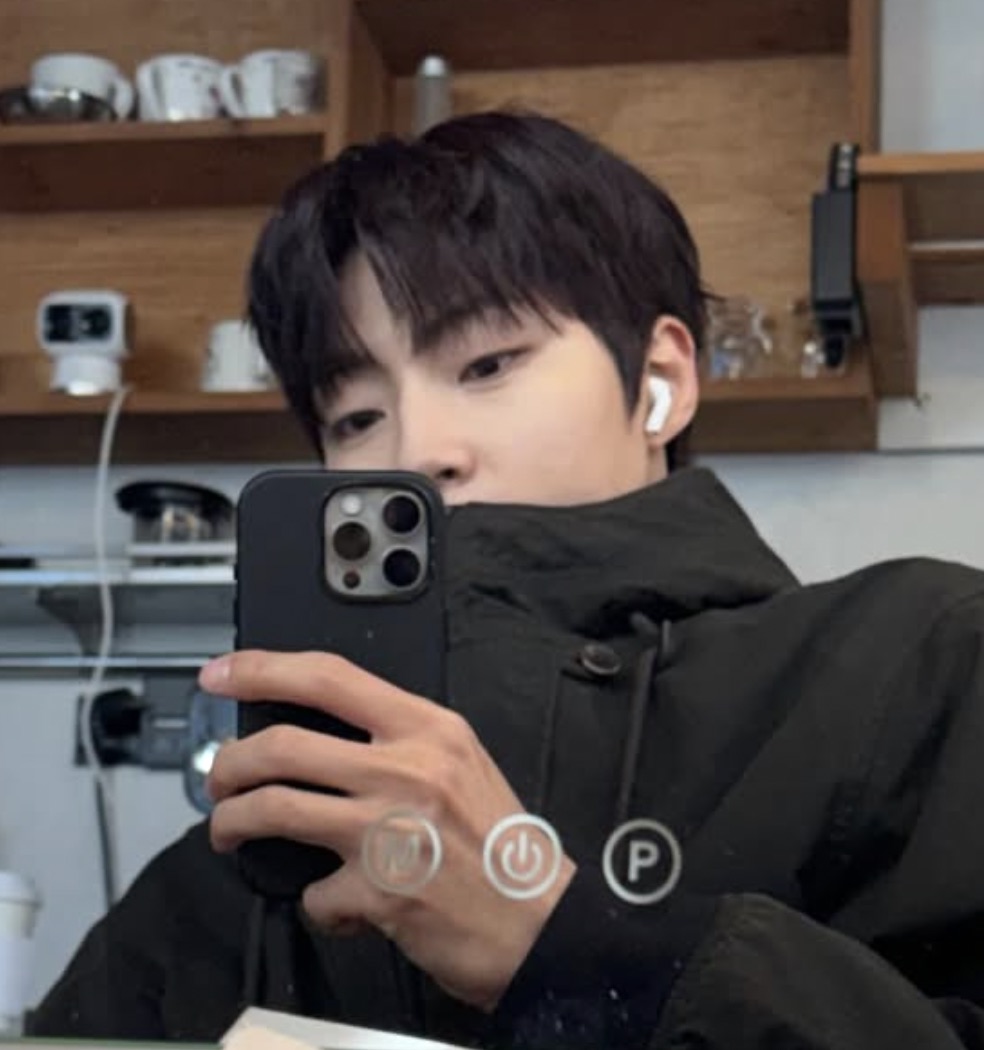 Hwang In-youp de casacão preto num café