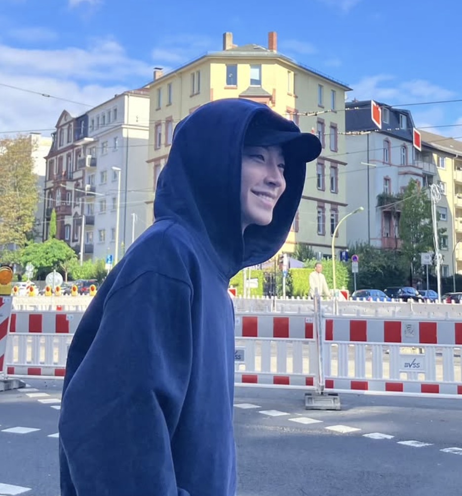 Hwang In-youp de moletom com capuz e boné na rua