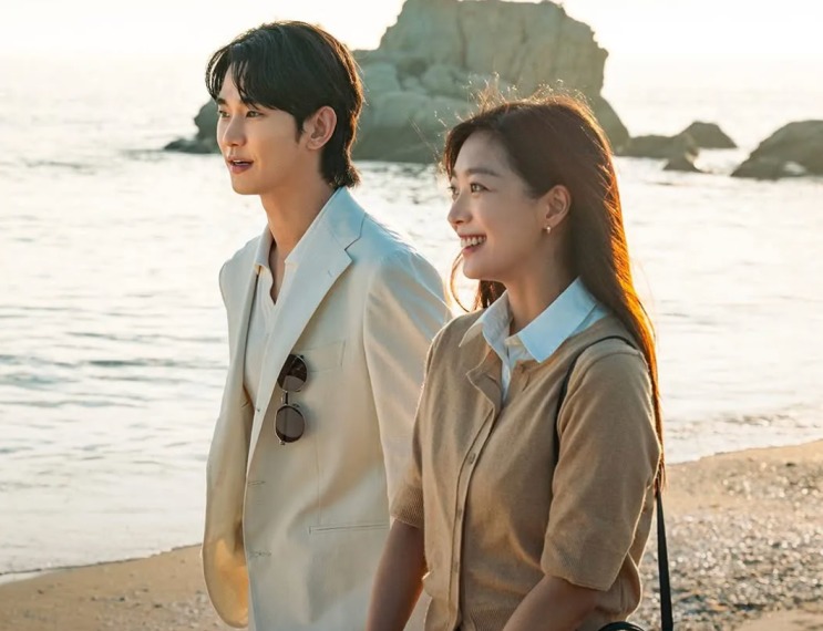 Cena de Knock-Off: Kim Soo-hyun e Jo Bo-ah caminhando na praia ao pôr do sol