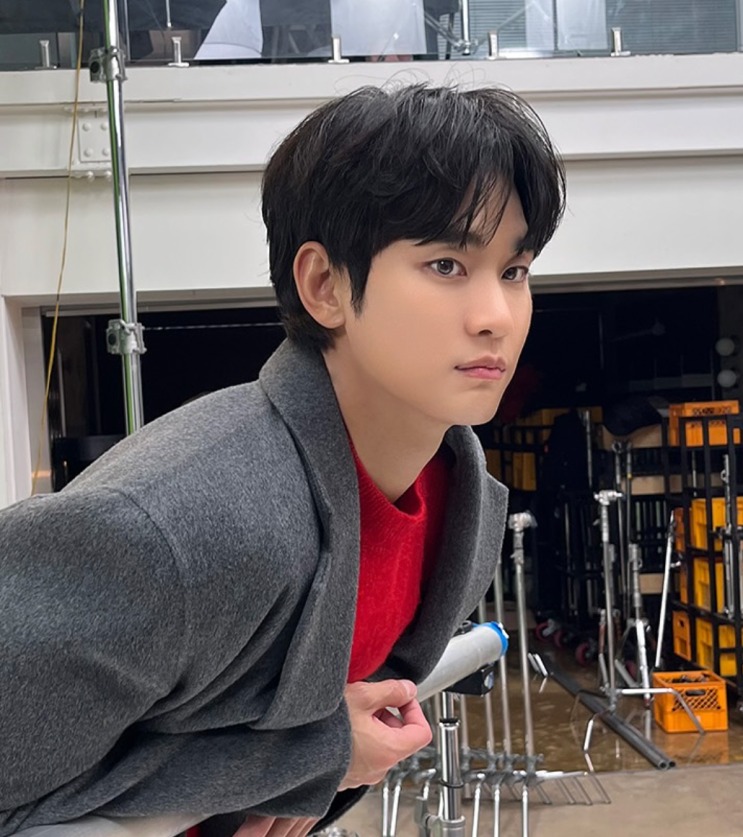 Kim Soo-hyun de casaco cinza, num set de filmagem