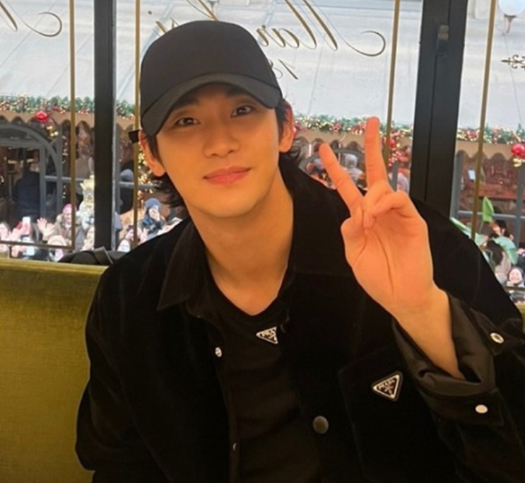 Kim Soo-hyun de boné preto, fazendo sinal de V