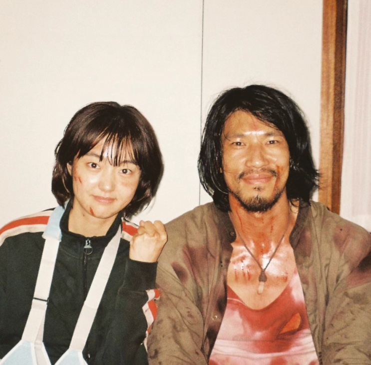 Kim Min e Kim Hye-jun com sangue cenográfico no rosto, nos bastidores