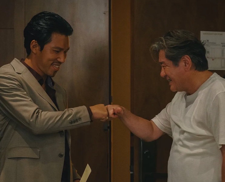Kim Min e Choi Min-sik batendo os punhos, sorrindo, nos bastidores