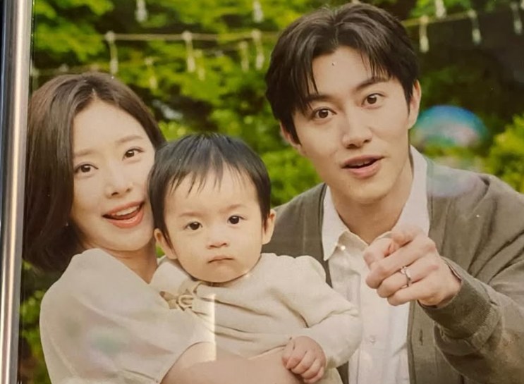 Hong Soo-cheol com a esposa e o bebê em Rainha das Lágrimas