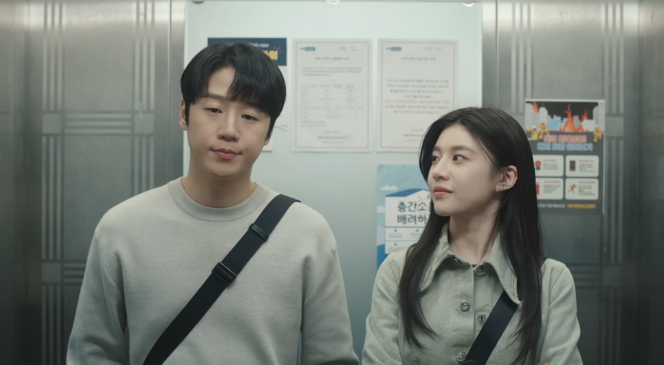 Jung Joon-won e Go Youn-jung lado a lado dentro de um elevador, ela olhando para ele