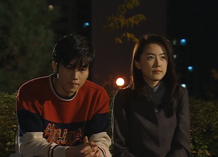 Lee Dong-wook jovem, sentado à noite ao lado de uma atriz