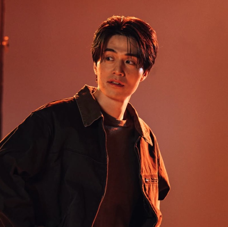 Lee Dong-wook atual, em ensaio fotográfico com fundo laranja