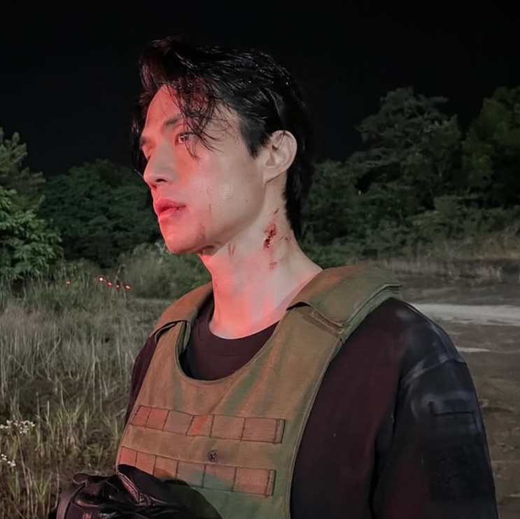 Lee Dong-wook de colete tático, em bastidor à noite