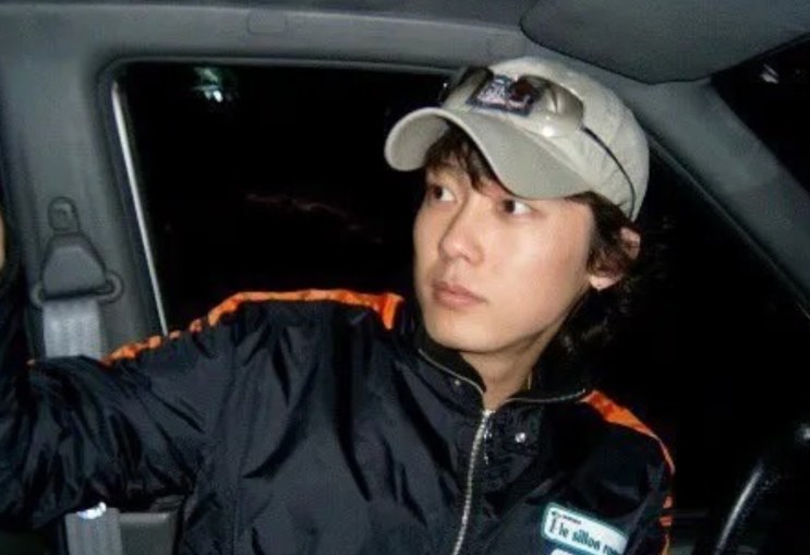 Park Byung-eun jovem, de boné dentro do carro