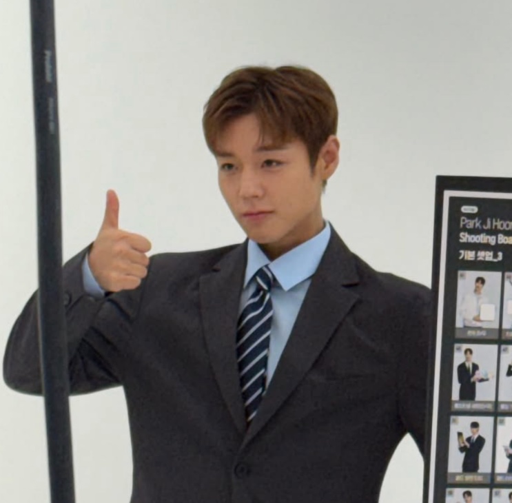 Park Ji-hoon de terno escuro fazendo joinha em um evento