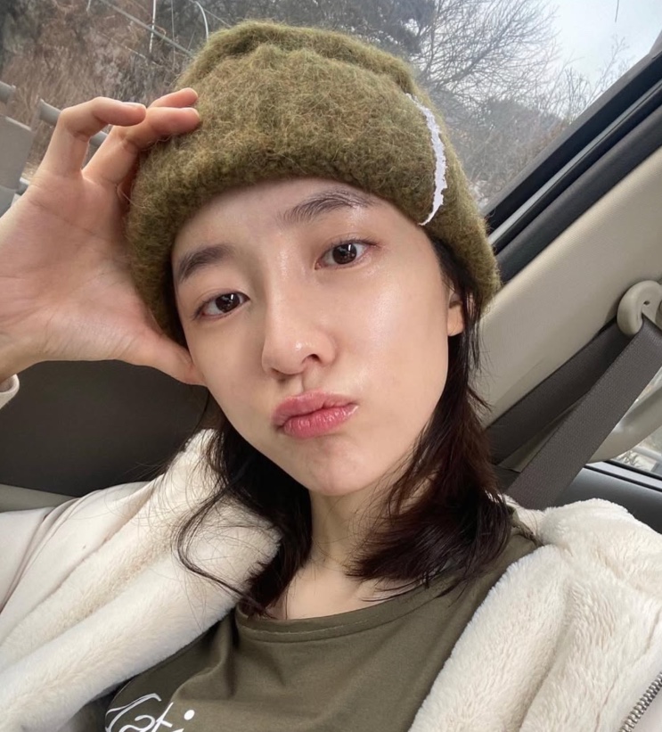Park Ji-hyun de gorro verde, numa selfie dentro do carro