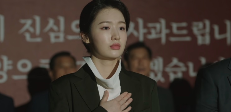 Jin Ye-jun de cabeça baixa ao lado de outras pessoas, no mesmo pedido de desculpas