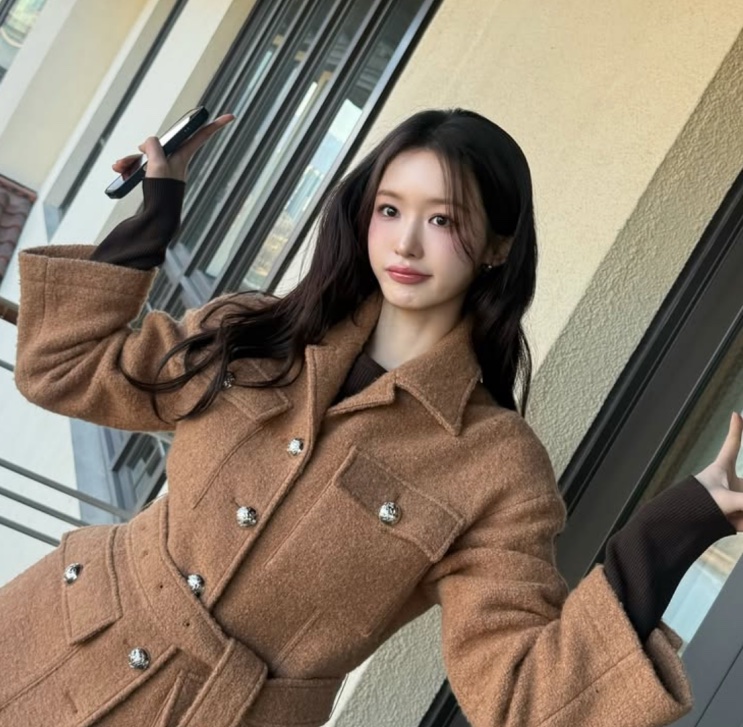 Cho Hye-joo de casaco bege, posando para uma foto em um corredor