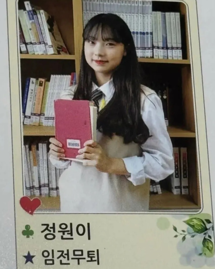 Página do álbum de formatura com a foto da Woni segurando um caderno e o lema dela escrito ao lado