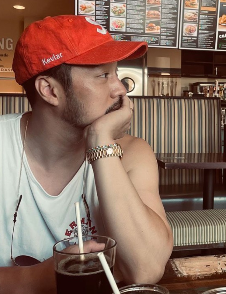 So Ji-sub de boné vermelho em um café