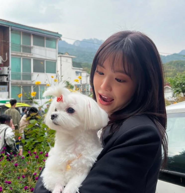 Son Na-eun nos bastidores, segurando um cachorrinho branco