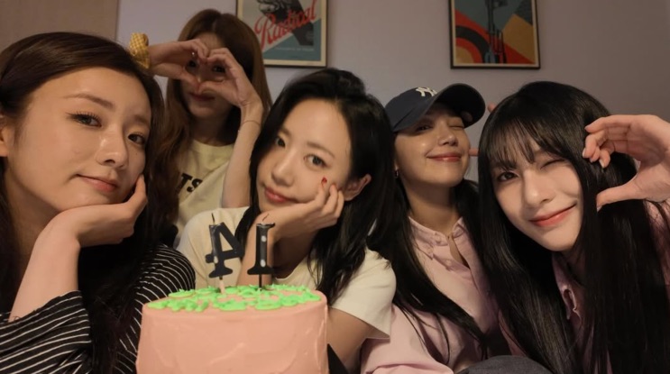 As integrantes do Apink juntas numa foto antiga, com um bolo