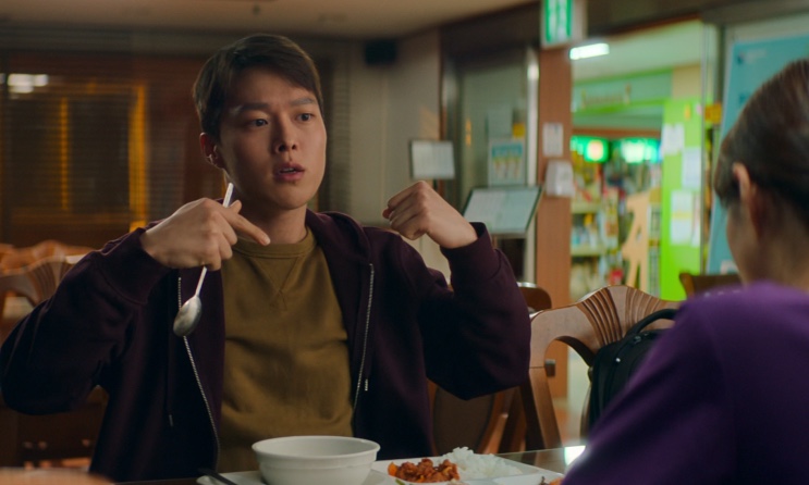 Jang-hyuk já magro, sentado à mesa do refeitório, em Sweet & Sour